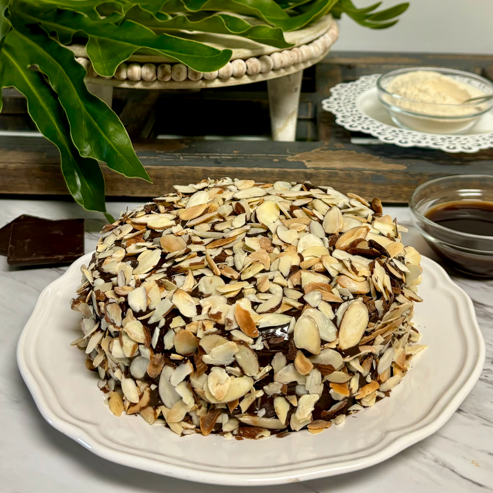 Gluten-free, dairy-free, sugar-free Vanilla Caramel Cake with a sugar-free caramel syrup drizzle and toasted almonds, showcasing its spongy texture and rich vanilla aroma. Full Life Gourmet Bakery